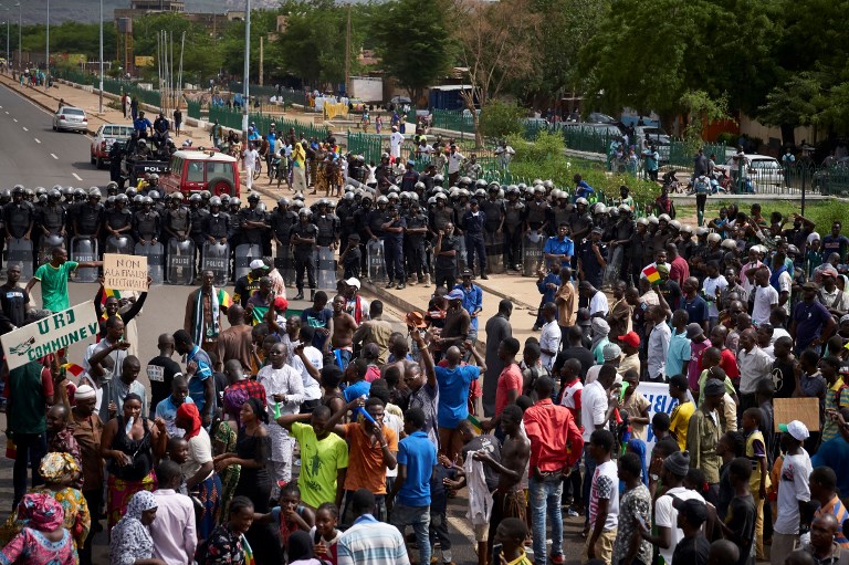 People face riot police forces during a demonstration to call for transparency in the upcoming presidential elections in Mali, on June 8, 2018 in Bamako. / AFP PHOTO / Michele CATTANI