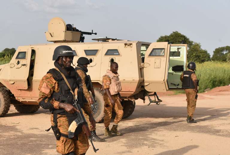 Burkinabe soldiers stand in position near the Presidental Security Regiment (RSP) military barracks on September 29, 2015 in Ouagadougou. Burkina Faso\'s government on September 28 accused an elite presidential guard, led by coup leader Gilbert Diendere, behind this month\'s week-long coup of refusing to disarm, of seizing loyalist troops, and of planning yet more trouble. \"The disarmament process started Saturday (September 26) was forcably questioned by General Diendére who informed his elements that the RSP can not be dissolved by the transitional goverment and it was better to resist,\" according to a government statement. AFP PHOTO / SIA KAMBOU