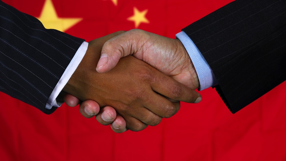 Business team shaking hands in front of the flag