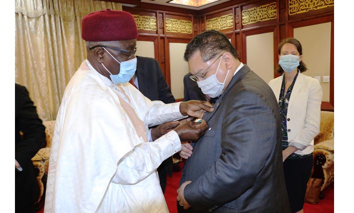 Le chef de la diplomatie nigérienne élevant Peter Pham au rand d\'officier dans l’ordre du mérite du Niger.