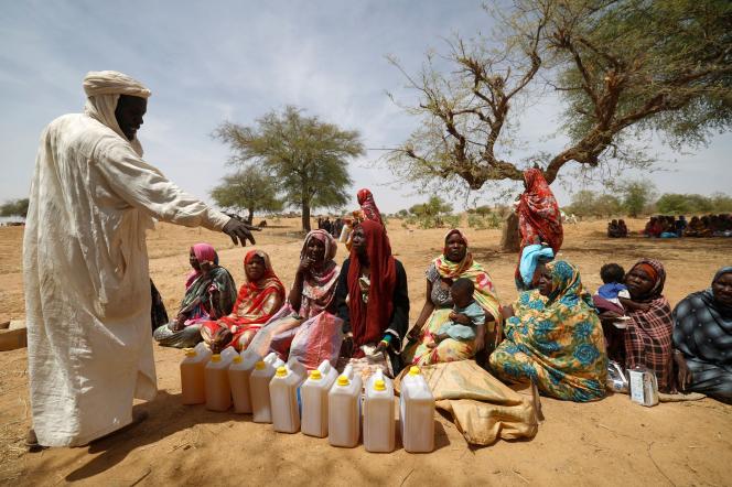 Sudanese refugees who have fled the violence in their country sit, as they receive food rations from World Food Programme (WFP), which they have to share equally, near the border between Sudan and Chad in Koufroun, Chad May 9, 2023. REUTERS/Zohra Bensemra