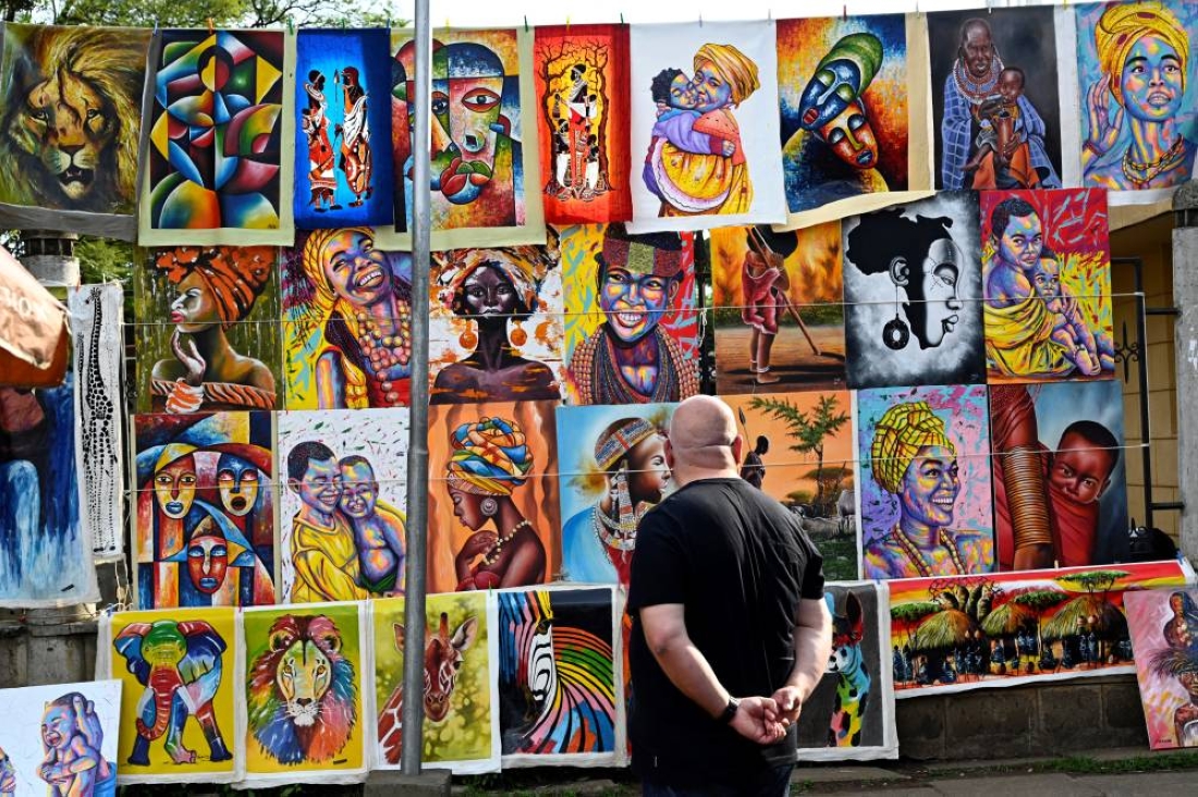 Un touriste admirant des tableaux relatant les "couleurs kenyanes"