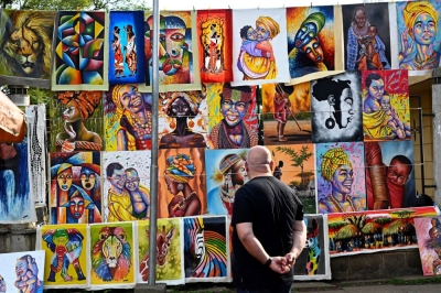 Un touriste admirant des tableaux relatant les "couleurs kenyanes"