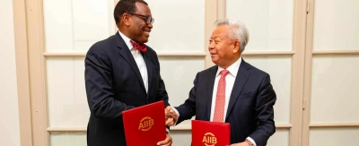 Le président du Groupe de la Banque africaine de développement, Akinwumi Adesina (à gauche), et le président de l’AIIB, Jin Liqun, se serrent la main après avoir signé un protocole d’accord renouvelant la collaboration entre leurs institutions pour un développement économique durable en Afrique.